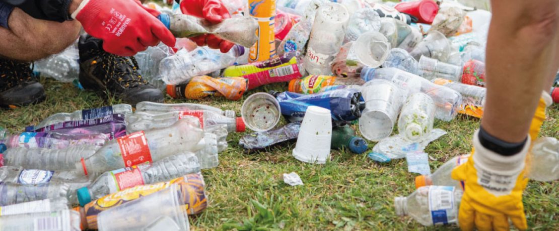 Hands with gloves counting littered plastic bottles