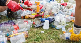 Hands with gloves counting littered plastic bottles